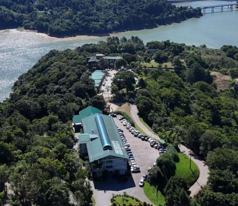 Vista aérea do Capivari Ecoresort, cercado de mata, à beira da represa