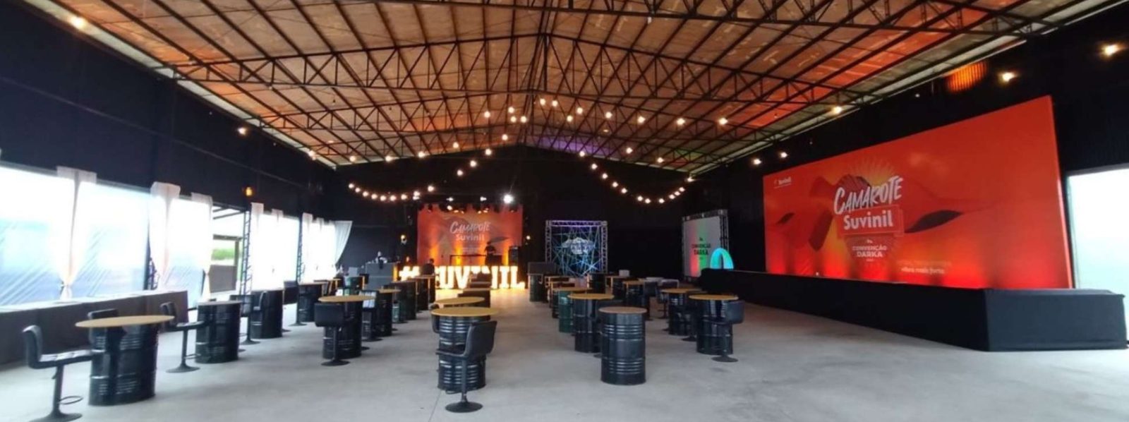 Pavilhão Araucária montado para evento corporativo, com palco, telões e mesas bistrô