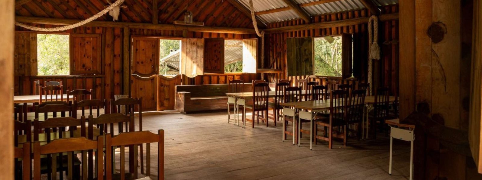 Salão do Rancho do Peão com mesas e cadeiras de madeira