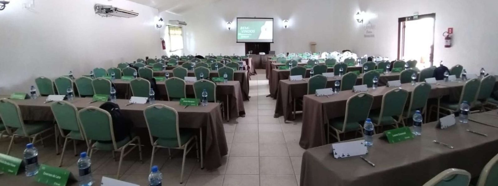 Sala de convenção do Capivari Ecoresort montada em formato escolar, com telão